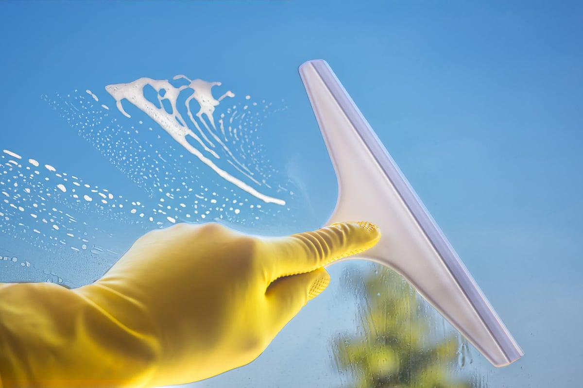 Professional window cleaning technician working on a residential home